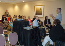 Msgr. Paul Tighe, right, secretary for the Vatican&rsquo;s Pontifical Council for Social Communications, discusses blogging during an impromptu meeting on June 23 at the Catholic Media Convention in Pittsburgh. Blogger Elizabeth Scalia, seated at right, also spoke during the meeting. (Photo by Sean Gallagher)