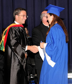 Harry Plummer, executive director of Catholic education and faith formation for the archdiocese, shakes hands with Bishop Chatard High School senior Claire Gorden, a member of Immaculate&nbsp;Heart Parish in Indianapolis, during commencement exercises on May 22 at the school. (Submitted photo)