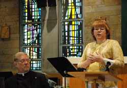 As the dean of the Terre Haute Deanery, Father Rick Ginther, left, listens during a July 14 press conference as Ann Ryan explains some of the changes that will result from a strategic plan to revitalize the Church in west central Indiana. Ryan is the communication chairperson of the Terre&nbsp;Haute Deanery Strategic Plan. (Photo by John Shaughnessy)