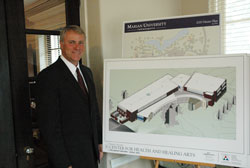 Daniel Elsener, president of Marian University in Indianapolis, stands in front of an architectural rendering of the university&rsquo;s Center for Health and Healing Arts, which is scheduled to open in 2013. The new building will house the college of osteopathic medicine, and the university&rsquo;s school of nursing. Marian will be the first Catholic university in the United States to have a college of osteopathic medicine. (Photo by John Shaughnessy)