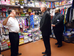 Mark Casper, left, director of St. Elizabeth-Catholic Charities in New&nbsp;Albany, stands in a storeroom at St. Elizabeth&rsquo;s transitional home on July 27. He is describing to Louisville Archbishop Joseph E. Kurtz and Father Anthony Chandler, pastor of Immaculate Conception Parish in LaGrange, Ky., the many interfaith contributions the agency receives, including baby clothes, diapers and car seats. (Photo by Patricia Happel Cornwell)