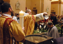 Benedictine Father Julian Peters, at the time administrator pro-tem of SS. Peter and Paul Cathedral Parish in Indianapolis, baptizes Scott Warpool during Cathedral Parish&rsquo;s Easter Vigil. Then-transitional Deacon Aaron Jenkins, holding the parish&rsquo;s Easter candle, stands at left. The Easter Vigil culminates the Rite of Christian Initiation of Adults, which is a primary means of adult faith formation in many parishes. (File photo by Sean Gallagher)
