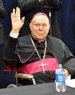 Archbishop Daniel M. Buechlein acknowledges the standing ovation that he received from priests, friends, archdiocesan employees and members of the media at the Archbishop Edward T. O&rsquo;Meara Catholic Center in Indianapolis on Sept. 21 after it was announced that he is retiring as shepherd of the Archdiocese of Indianapolis. (Photo by Mary Ann Garber)