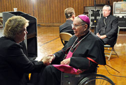 Jackie Byers, left, speaks to Archbishop Emeritus Daniel M. Buechlein after a press conference announcing his retirement on Sept. 21. Byers, a member of St. Simon the Apostle Parish in Indianapolis, is past president of the Archdiocesan Finance Council. Bishop Christopher J. Coyne, right, the archdiocese&rsquo;s new apostolic administrator, talks with Kevin Rader, a reporter for WTHR Channel 13 in Indianapolis. (Photo by Mary Ann Garber)