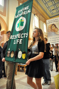 Myles Hesse, left, and Hannah Miller, both freshmen at Father Michael Shawe Memorial Jr./Sr. High School in Madison, carry a banner from their school at the start of the annual archdiocesan Respect&nbsp;Life Sunday Mass on Oct. 2 at SS. Peter and Paul Cathedral in Indianapolis. Myles and Hannah are members of Prince of Peace Parish in Madison. (Photo by Sean Gallagher)