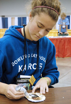 Rachel Schmidt, 17, a member of St. Pius X Parish in Urbandale, Iowa, creates a Christmas card for an American soldier serving overseas during the holidays&mdash;part of the service emphasis that marked the National Catholic Youth Conference in Indianapolis on Nov. 17-19. (Photo by John Shaughnessy)