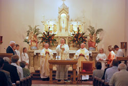 Bishop Christopher J. Coyne, center, apostolic administrator, prays the eucharistic prayer during a Nov. 6 Mass at St. John the Baptist Church in Starlight that celebrated the New Albany Deanery faith community&rsquo;s 150th anniversary. Concelebrating the Mass were, from left, Father Harold Ripperger, a former administrator of the parish, and Father Wilfred &ldquo;Sonny&rdquo; Day, current pastor. (Submitted photo)