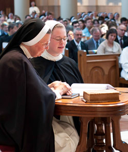 Holding her right hand on a copy of her religious community&rsquo;s constitutions, Dominican Sister Imelda Grace Lee, right, professes her first vows as a member of the Nashville, Tenn.-based Dominican Sisters of St. Cecilia on July 28, 2011. Holding her hand is Mother Ann Marie Karlovic, superior of the community. The liturgy in which Sister Imelda Grace professed her vows took place in the Cathedral of the Incarnation in Nashville. Sister Imelda Grace is a former member of Christ the King Parish and a graduate of Bishop Chatard High School, both in Indianapolis. (Submitted photo)