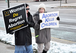 St. Susanna parishioner Judy York of Plainfield, right, and Photini James, a member of Joy of All Who Sorrow Orthodox Church in Indianapolis, carry pro-life signs during a Respect Life March organized by Right to Life of Indianapolis on Jan. 15 at the conclusion of the organization&rsquo;s annual Memorial Service for the Unborn at the Indiana War Memorial. (Photo by Mary Ann Garber)
