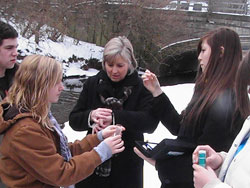 Cardinal Ritter Jr./Sr. High School science teacher Mary&nbsp;Pat O&rsquo;Connor, center, helps seniors Charlie Elliott, from left, Claire Osecki and Vanessa Lynn collect water samples from Crooked Creek in Indianapolis during an ecology class field trip in January 2011. The students graduated on June 3. (Submitted photo)