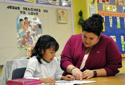 Sarah Watson, principal of the consolidated St. Michael and St. Gabriel elementary schools in Indianapolis, helps kindergartner Mia Rodriguez with an assignment in teacher Lisa Zetzl&rsquo;s class on Jan. 12 at the Indianapolis West Deanery school. (Photo by Mary Ann Garber)