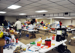 Volunteers sort donated relief items stored in the basement of St.&nbsp;Francis Xavier Church in Henryville on March 3. Since the church came through the March 2 tornado that ripped through the town relatively unscathed, it quickly became a center for the collection and distribution of food, clothing, blankets and other items to people affected by the storm. Within hours, the basement was filled with donations and some had to be stored in the church's worship space. (Photo by Sean Gallagher)