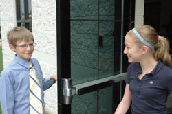 Saben Fletcher opens the door for Grace Meier at St. Michael School in Greenfield, displaying one of the thoughtful acts that earned him the distinction as the Gentleman of the Year for the school&rsquo;s Crusaders for Christ Gentlemen&rsquo;s Club&mdash;a club that seeks to develop faith, values and manners in male middle school students. Both Saben and Grace are seventh-grade students at St. Michael School. (Photo by John Shaughnessy)