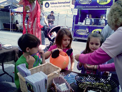 Patty Watson, a member of Our Lady of Perpetual Help Parish in New Albany, talks on Oct. 9, 2011, with, from left, Evan and Lauren McCombs, also parishioners, and another visitor to a booth sponsored by the parish that was part of New Albany&rsquo;s annual &ldquo;Harvest Homecoming&rdquo; Festival. The booth was organized by Our Lady of Perpetual Help&rsquo;s Committee on Evangelization. Evan and Lauren are, respectively, in kindergarten and the second-grade at Our Lady of Perpetual Help School. (Submitted photo)