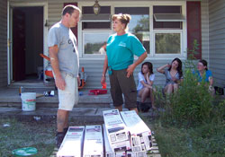 As coordinator of disaster preparedness and response for Catholic Charities in the archdiocese, Jane Crady talks with volunteer Pierre Gerber about the next step in restoring a home in Henryville that was damaged by a deadly tornado on March 2. Crady says she has experienced the touch of God daily in the volunteers who have come to help restore people&rsquo;s homes and lives. (Submitted photo)