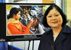 Catholic Relief Services president and chief executive officer Carolyn Woo, a former Hoosier, poses for a photograph on June 21 in front of a poster featuring the lifesaving work of the U.S. Church&rsquo;s international humanitarian aid organization. Woo was a keynote speaker at the Catholic Media Conference in Indianapolis. (Photo by Mary Ann Garber)