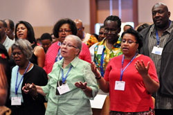 Opal Easter-Smith, from left, Margo Butler and Adrienne Curry from the Archdiocese&nbsp;of Chicago pray during the&nbsp;National Black Catholic Congress Mass on July 20 in Indianapolis. During the congress, Benedictine Father Cyprian&nbsp;Davis of Saint Meinrad Archabbey in St. Meinrad was honored with a lifetime achievement award. (Photo by Mary Ann Garber)