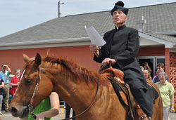 Father Paul Landwerlen, administrator of St. Vincent de Paul Parish in Shelby County, reads a proclamation about the faith community&rsquo;s 175-year history after riding a horse onto its grounds on June 24 during an event to kick off a series of celebrations of its anniversary. St. Vincent&rsquo;s founding pastor, Father Vincent Bacquelin, rode on horseback from the Shelby County parish to minister to Catholics throughout central and eastern Indiana. (Submitted photo by Jennifer Lindberg)