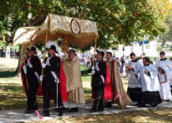 Father Robert Robeson, rector of Bishop Simon Bruté College Seminary in Indianapolis, carries a monstrance during the “Eucharistic Rosary Rally for the Protection of Our Religious Liberties” procession on Sept. 30 at Marian University in Indianapolis. Father Jerry Byrd, associate pastor of St. Barnabas Parish in Indianapolis, follows him with members of the Fourth Degree Knights of Columbus and archdiocesan seminarians. (Submitted photos by Daniel Roy)