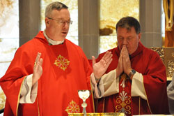 Bishop Christopher J. Coyne, apostolic administrator, left, prays part of a eucharistic prayer while Archbishop Joseph W. Tobin prays in silence during an Oct. 19 Mass at the St. Augustine Home for the Aged Chapel in Indianapolis. The liturgy with the Little Sisters of the Poor and elderly residents of the home was among Archbishop Tobin&rsquo;s first pastoral visits after his appointment was announced by Pope Benedict XVI on Oct. 18. See related story on page 47. (Photo by Mary Ann Garber)