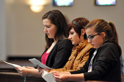 St. Simon the Apostle parishioner and Archdiocesan Youth Council member Annie Fleming of Indianapolis, left, prays the rosary with Our Lady of the Greenwood parishioners Bridget Bard, center, and Corina Defenderfer, right, of Greenwood during a holy hour for vocations to the priesthood and religious life on Dec. 1 at Our Lady of the Greenwood Church. They helped the archdiocesan seminarians lead the gathering of youths, young adults, adults, and men and women religious as part of &ldquo;A Mission of Prayer&mdash;A Year of Faith with Archbishop [Joseph W.] Tobin&rdquo; at the Indianapolis South Deanery parish. (Photo by Mary Ann Garber)