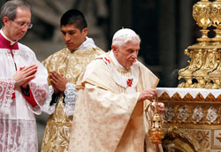 Pope Benedict XVI uses incense as he celebrates Christmas Eve Mass in St. Peter&rsquo;s Basilica at the Vatican on Dec. 24. Pontifical North American College seminarian Martin Rodriguez of Indianapolis, center, served during the liturgy. (CNS photo/Paul Haring)