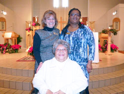 At 83, Teresa Moore smiles after fulfilling her lifelong dream of joining the Catholic Church during a Mass at St. Monica Parish in Indianapolis on Jan. 6. Moore is joined in the photo by, left, Anne Corcoran, parish pastoral associate, and Dabrice Bartet, Moore&rsquo;s sponsor. (Submitted photo/Kent Hughes)