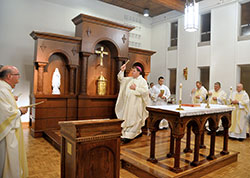 Archbishop Joseph W. Tobin, center, blesses the renovated chapel of Bishop Simon Brut&eacute; Seminary in Indianapolis during a Jan. 28 Mass. One feature of the renovated chapel is the altar piece, or reredos, that stands behind the chapel&rsquo;s altar. The reredos was designed by Eric Atkins, archdiocesan director of management services. (Photo by Sean Gallagher)