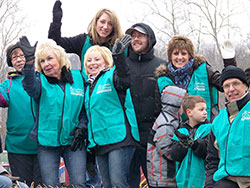 Members of the Catholic Charities Disaster Response Team ride a float during a March 2 parade in Henryville commemorating the one-year anniversary of southern Indiana&rsquo;s tornadoes. Father Steven Schaftlein, pastor of St. Francis Xavier Parish in Henryville and St. Michael Parish in Charlestown, sits on the far right of the float. (Submitted photo)