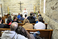 Couples participating in the &ldquo;One in Christ&rdquo; marriage preparation program listen as Msgr. Joseph Schaedel, pastor of St. Luke the Evangelist Parish in Indianapolis, explains the Mass in the parish&rsquo;s chapel on April 13. (Photo by Natalie Hoefer)