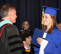 Principal John Atha of Bishop Chatard High School in Indianapolis presents a diploma to Arden Burch during the school&rsquo;s 2012 graduation. (Submitted photo)
