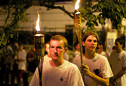 John Paul Cole, left, and Alex Jackson, participants in the Bishop Brut&eacute; Days vocations camp, carry torches during a eucharistic procession on June 12. (Photos by Charles Pe&ntilde;alosa)
