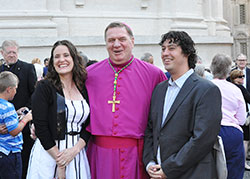Sarah and Greg Hempstead, members of Immaculate Heart of Mary Parish in Indianapolis, are shown with Archbishop Joseph W. Tobin outside of St. Peter&rsquo;s Basilica at the Vatican on June 29. The Hempsteads traveled to Italy to attend the pallium Mass with a group from Marian University in Indianapolis.	(Photo	by John Shaughnessy)