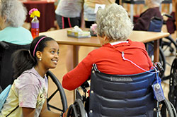 Mary Peach enjoys a conversation with a resident at the Golden LivingCenter nursing home in Greenfield on June 19. The visit to the nursing home was one of four service opportunities for participants at the &ldquo;Girls Getaway&rdquo; three-day service camp offered through the Challenge program at St. Michael Parish in Greenfield. (Photo by Natalie Hoefer)
