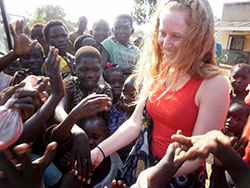 In this Jan. 20 photo, Alexandra &ldquo;Alex&rdquo; Servie is greeted by children at a Radio Pacis event in a village near Arua, Uganda. (Submitted photo)