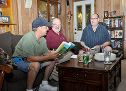 St. Monica Parish members Todd Kowinski, left, Charles &ldquo;Nick&rdquo; Georges and Dan Bedillion, three of the eight members of a St. Monica Parish small church communities group, respond to the message they hear in the upcoming Sunday Scriptures at their meeting at Kowinski&rsquo;s home on Aug. 27. (Photo by Natalie Hoefer)