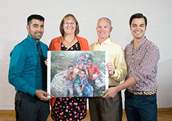 The family of Brooke Lahr holds up a portrait of her with children during a mission trip that she made to Honduras. The family photo was taken during a Sept. 15 gathering at Bellarmine University in Louisville, where Brooke attended college. Brooke&rsquo;s parents have established a missionary endowment in their daughter&rsquo;s memory. Pictured from left, Brooke&rsquo;s brother, Anthony; her mother and father, Colleen and Mark; and her brother, Paul. (Photograph by Sarah Albritton of Serendipity Portraits )