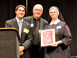 Right to Life of Indianapolis&rsquo; 2013 Respect for Life Award is presented to Servants of the Gospel of Life Sister Diane Carollo at the organization&rsquo;s Celebrate Life dinner at the Indiana Convention Center in Indianapolis on Sept. 17. Making the presentation is Marc Tuttle, president of Right to Life of Indianapolis. Msgr. Joseph Schaedel, pastor of St. Luke the Evangelist Parish in Indianapolis, is also pictured. Sister Diane has devoted her life to the pro-life cause since 1971. (Photo by Natalie Hoefer)