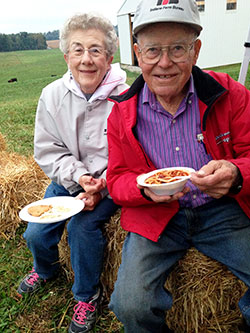 Joan and Pete Schickel, who have hosted the New Albany Deanery&rsquo;s fall youth Mass at their family farm since 1983, enjoy dinner. (Photo by Leslie Lynch)