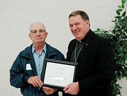 Clem Maga receives a 2013 Catholic Charities Summit Award from Archbishop Joseph W. Tobin on Oct. 9. The award honors Catholic Charities staff members who have &ldquo;gone above and beyond in living the mission and values of Catholic Charities in serving those in need, especially the poor.&rdquo; (Photo by John Shaughnessy)