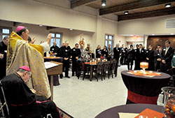 Archbishop Joseph W. Tobin raises his hands in prayer on Oct. 21 while blessing the new dining hall and dormitory of Bishop Simon Brut&eacute; College Seminary in Indianapolis. Archbishop Emeritus Daniel M. Buechlein attended the ceremony. The new dining hall is named after him. (Photo by Sean Gallagher)