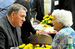 Archbishop Joseph W. Tobin speaks with Teresa Horan, a member of St. Mary Parish in Greensburg, at the Catholic Community Foundation (CCF) annual meeting on Oct. 30 at the Archbishop O&rsquo;Meara Catholic Center in Indianapolis. Her son, Donald Horan, a past CCF board of trustees&rsquo; member, died in a plane crash last December with his wife, Barbara, and their friends Stephen and Denise Butz. All were members of St. Mary Parish in Greensburg. (Photo by Natalie Hoefer)