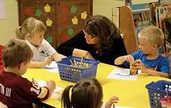 The archdiocese&rsquo;s superintendent of Catholic schools Gina Fleming listens as kindergarten students Tori Benyon and Connor Baldwin of St. Rose of Lima School in Franklin share their reasons for why they appreciate their school. Fleming has made it her goal to visit all 68 Catholic schools during this school year to learn what makes them special. (Submitted photo)