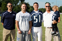 Pete Corrao began his 25 years as volunteer announcer for Our Lady of Providence Jr.-Sr. High School in Clarksville long before his three sons played football for the school. From left, his son, Phil, a 1999 Providence graduate, is now an assistant coach for the team; Spencer just finished his junior season at Hanover College; and Tony just finished his senior season at Providence. Pete holds Phil&rsquo;s daughter, Reagan. (Submitted photo)