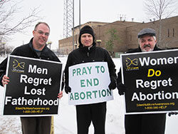 Jim Baily, left, a member of St. Patrick Parish in Terre Haute, Father John Hollowell, pastor of Annunciation Parish in Brazil and sacramental minister of Sacred Heart of Jesus Parish in Terre Haute, and Blaine Akers, a member of Annunciation Parish in Brazil, hold pro-life signs during an hour of prayer in front of the Vigo County Court House in Terre Haute on Jan. 22 to peacefully mark the 41st anniversary of the U.S. Supreme Court&rsquo;s Jan. 22, 1973, Roe v. Wade and Doe v. Bolton decisions that legalized abortion across the country. (Submitted photo by Tom McBroom)