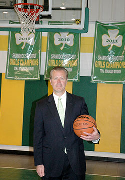 Wearing a jacket and one of his trademark neckties&mdash;a gift given to him by one of his teams&mdash;coach Joe Etling stands on the court at St. Patrick School in Terre Haute on April 24. Etling is retiring after coaching Irish basketball teams at the school for 17 years. (Photo by Mike Krokos)