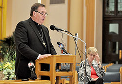 Archbishop Joseph W. Tobin speaks during a May 21 press conference held at SS. Peter and Paul Cathedral in Indianapolis in which he announced decisions regarding the Connected in the Spirit planning process for the four metropolitan Indianapolis deaneries. Archdiocesan chancellor Annette &ldquo;Mickey&rdquo; Lentz, right, looks on during the press conference. (Photo by Sean Gallagher)
