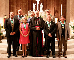 The 2014 St. John Bosco Award recipients pose for a photograph at SS. Peter and Paul Cathedral in Indianapolis with Bishop Christopher J. Coyne during the May 6 Volunteer Awards Ceremony sponsored by the archdiocese&rsquo;s Catholic Youth Organization and the Office of Youth Ministry. The recipients in the front row are, from left, Dan Deak,  Kathleen Miller, Mark Liegibel and Kurt Smith. The recipients in the back row are, from left, Nick Wehlage, Patrick Soller and Ken Blackwell. (Submitted photo by Jennifer Peterson of Catholic Youth Organization)