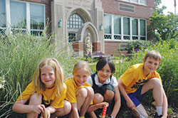 Several members of the Earth Council at St. Thomas Aquinas School in Indianapolis pose for a photo in a garden at the school, which was named a 2014 &ldquo;Green Ribbon School&rdquo; by the U.S. Department of Education. Reese Sochacki, left, Maisie McMahon, Maggie Gonzalez and Hank Fleetwood helped plant flowers in the garden. (Photo by John Shaughnessy)