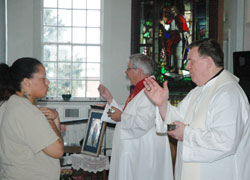 Archbishop Joseph W. Tobin blesses Erica McCaffery during a Mass that he celebrated in the chapel at the Indiana Women&rsquo;s Prison in Indianapolis on June 29. To his left distributing Communion is Deacon Dan Collier. About 15 Catholic volunteers visit and teach the women in prison every week. (Photo by John Shaughnessy)